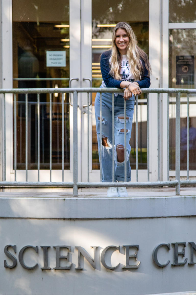 Adriana Sevy poses on the balcony in front of the Rickey Science Center