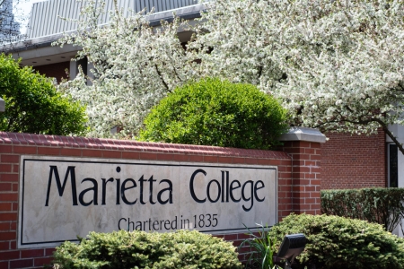 The entrance to Marietta College with blooming trees behind it